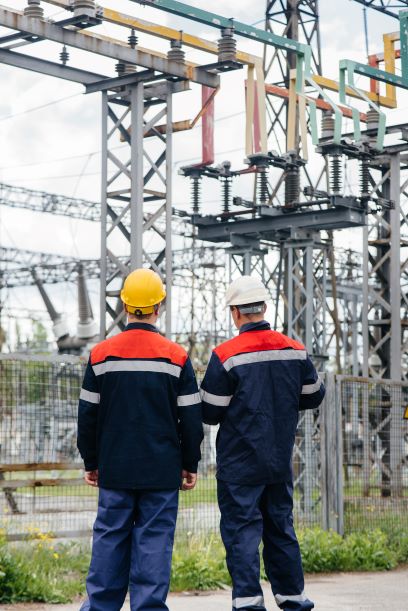 two specialist electrical substation engineers inspect modern high voltage equipment